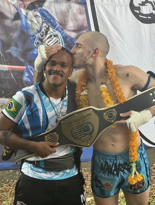 O mesmo atleta, agora campeão do Top Fighters, beijando a cabeça do Professor Rubens em agradecimento